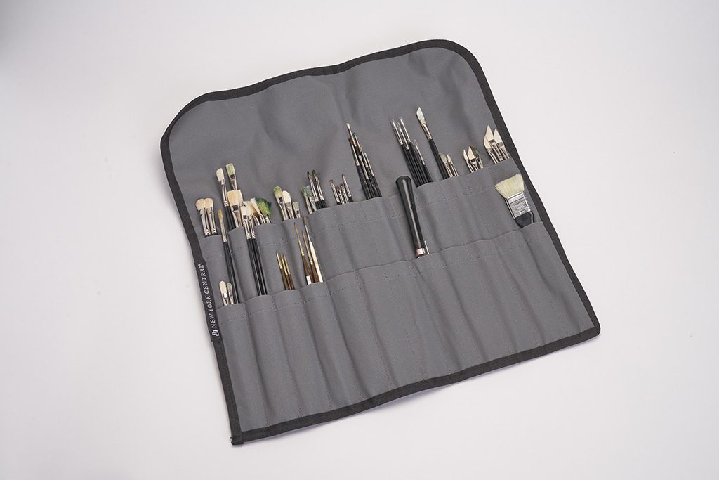 DebraJudd03_2025_33_web A roll of black cloth with many different brushes in it.